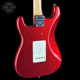 A close-up of the back of a red glitter electric guitar body with a maple neck, black pickguard, and a visible 'Tone Shop' watermark in the top left corner.