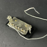 Guitar pickup on a dark surface with visible branding