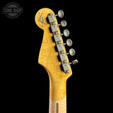 Close-up of the headstock of a Fender electric guitar with a natural maple wood finish and silver tuning pegs, shown against a solid black background with a Tone Shop watermark in the top left corner.