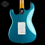 Fender Stratocaster electric guitar body in turquoise blue with a maple neck, shown from the back against a black background.