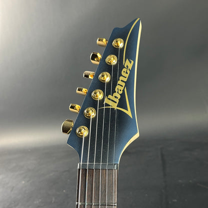 Guitar headstock with Ibanez logo on a dark background
