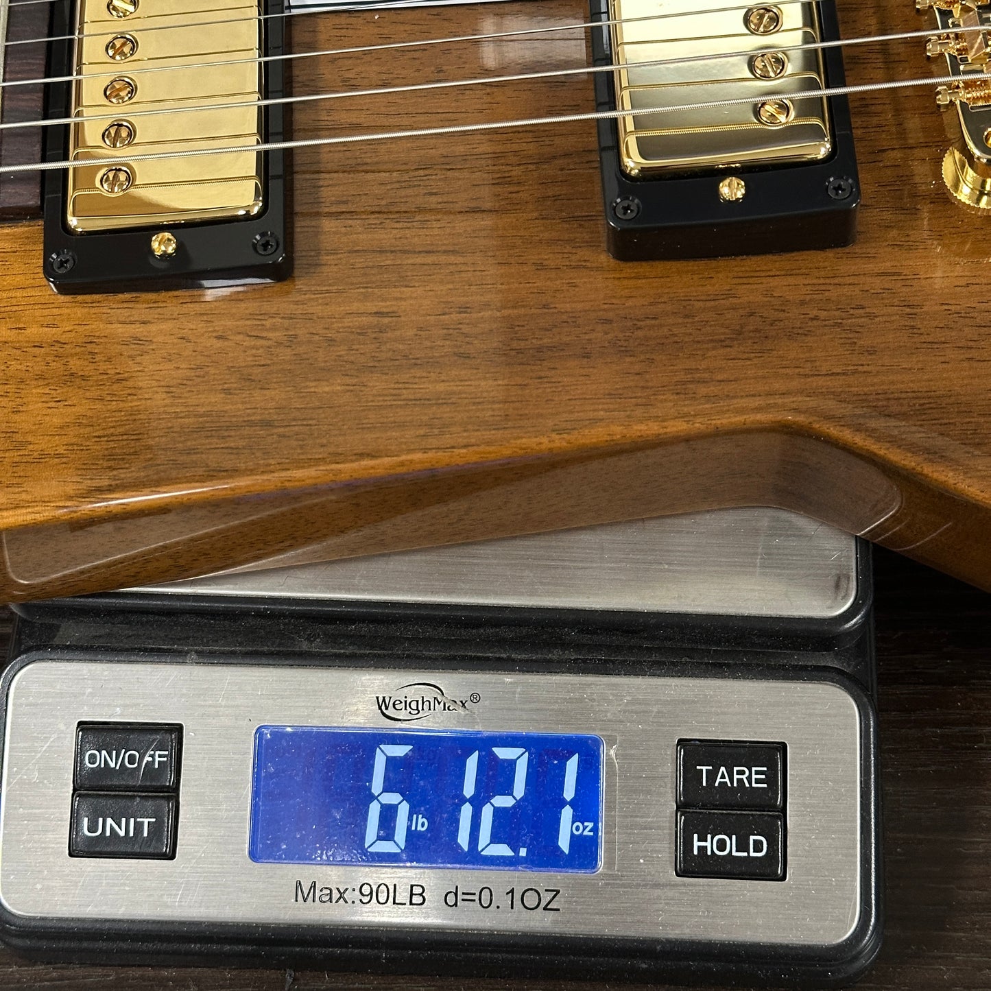 Guitar on a digital scale displaying weight