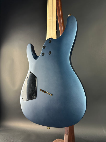 Back view of a blue electric guitar on a gray background