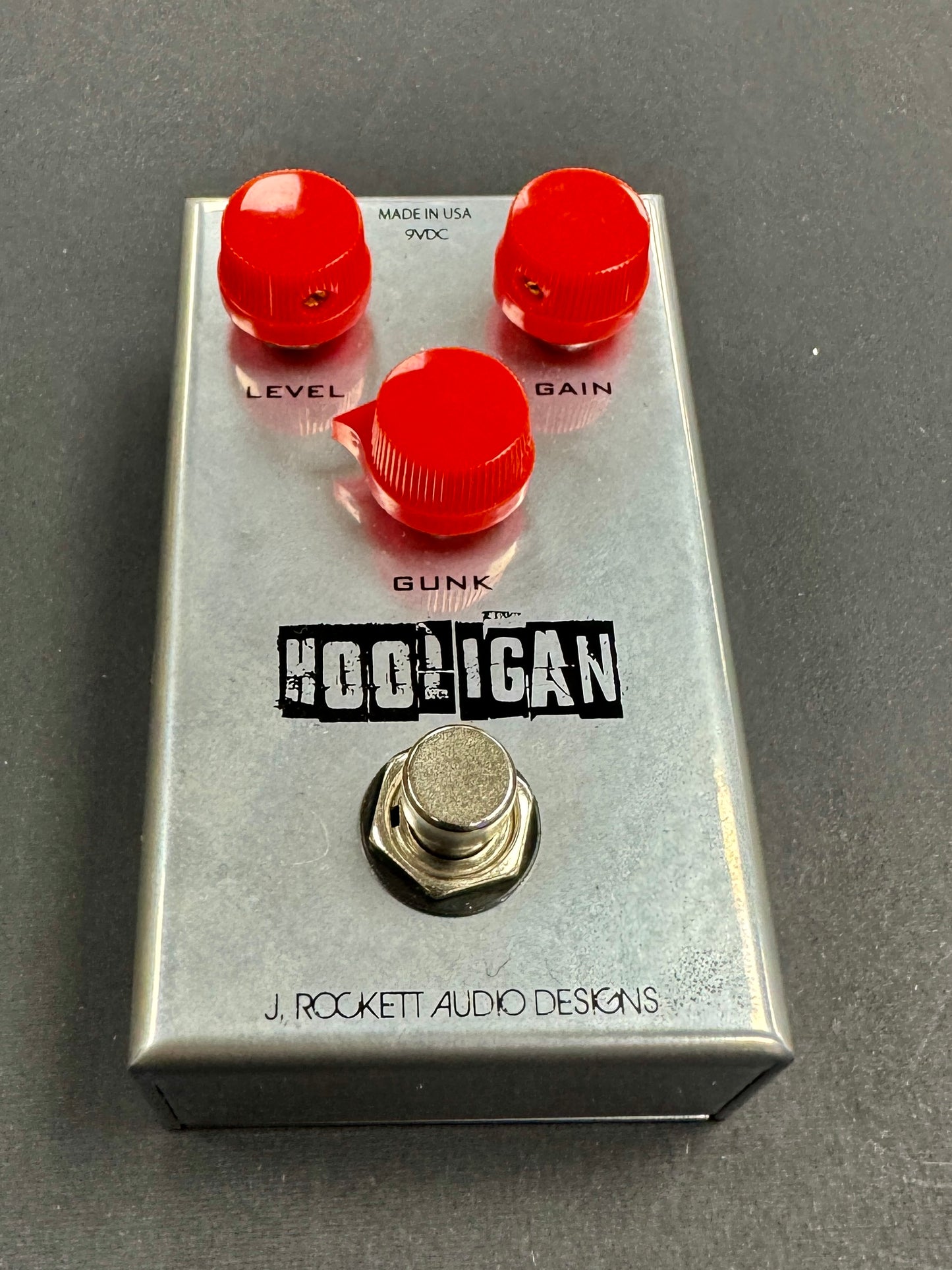 Guitar effects pedal with red knobs and 'Hooligan' branding on a gray background