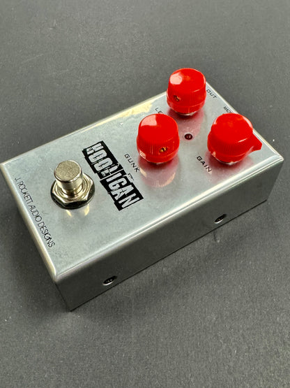 Effect pedal with red knobs and a brand label on a gray background