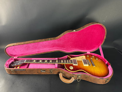 Gibson Les Paul guitar in a pink-lined case on a black background