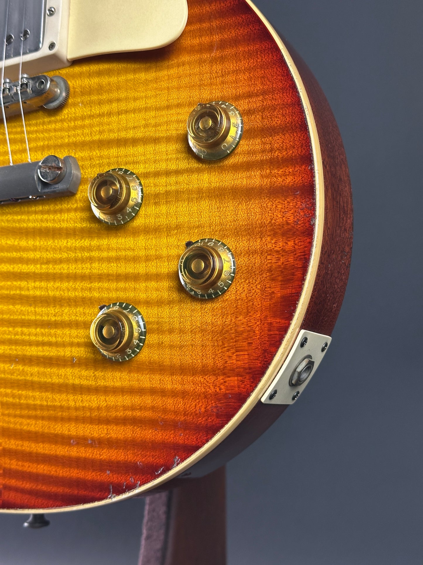 Close-up of a guitar's headstock with tuning pegs on a dark background
