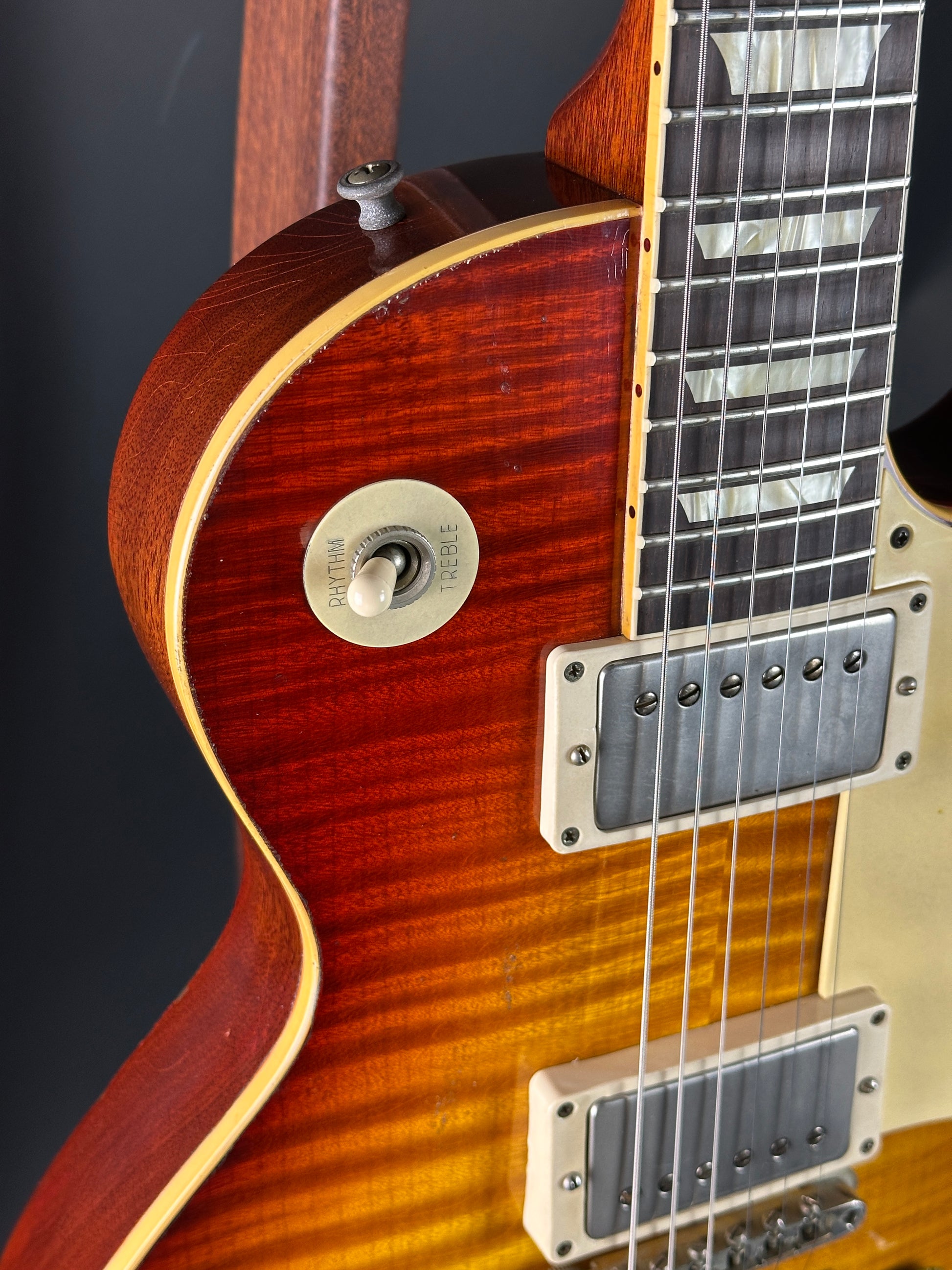 Close-up of a guitar's neck and body with a focus on the wood grain and hardware.