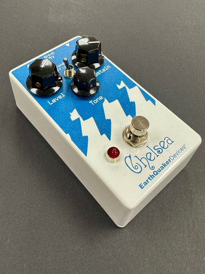 White guitar effects pedal with blue accents and 'Chelsea' branding on a gray background