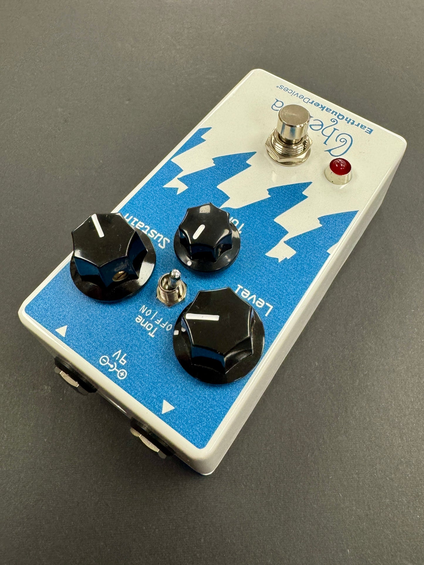 Guitar effects pedal with blue and white design on a gray background