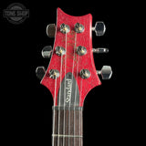 Close-up of a red guitar headstock with tuning pegs on a black background, featuring the 'Tone Shop' logo.