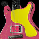 Close-up of a pink electric guitar body with a bright yellow pickguard, black fretboard, and distressed splatter finish against a black background. A Tone Shop watermark is visible in the top left.