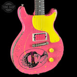 A pink electric guitar with a bright yellow pickguard, yellow knobs, and yellow paint splatter details, featuring a graphic of Jim Morrison on the lower bout. The guitar is shown against a solid black background with a Tone Shop watermark in the top left corner.