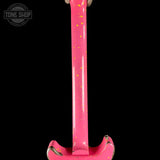 Close-up of a bright pink electric guitar body tailpiece area with gold glitter and distressed silver edges, shown against a black background with a Tone Shop watermark in the upper left.