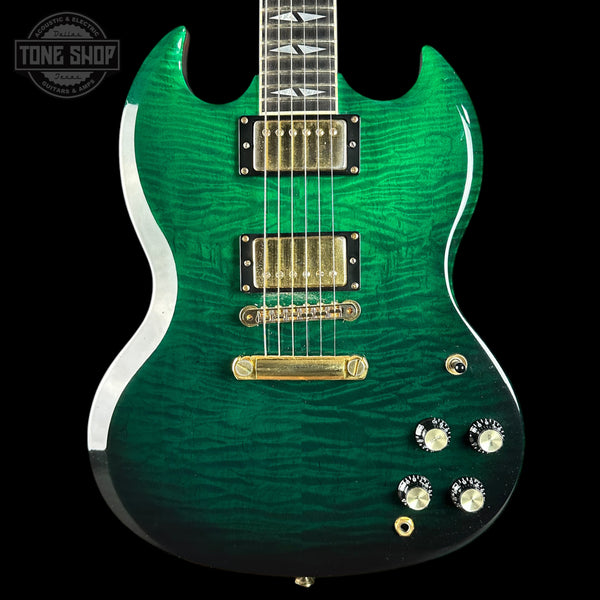 Green electric guitar with gold hardware on a black background, featuring 'Tone Shop' logo.