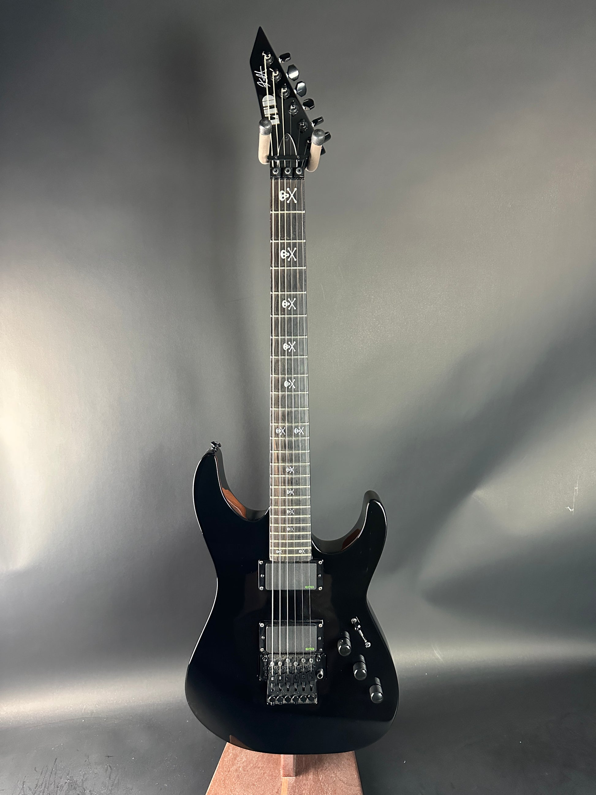 Black electric guitar on a gray background