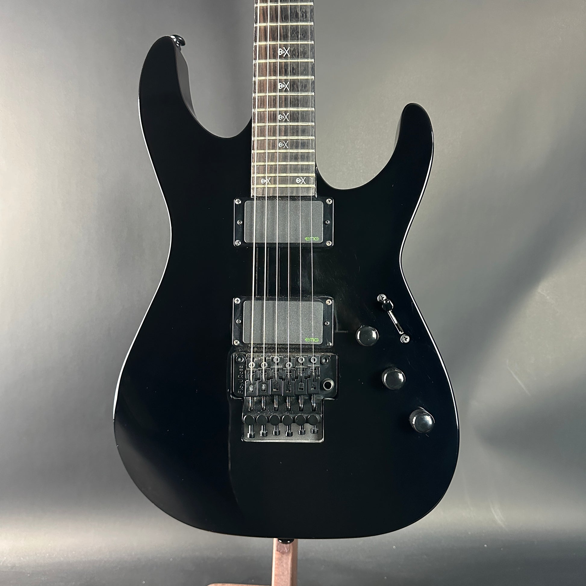 Black electric guitar on a gray background