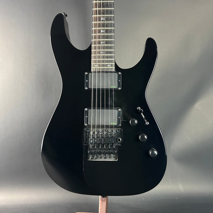 Black electric guitar on a gray background