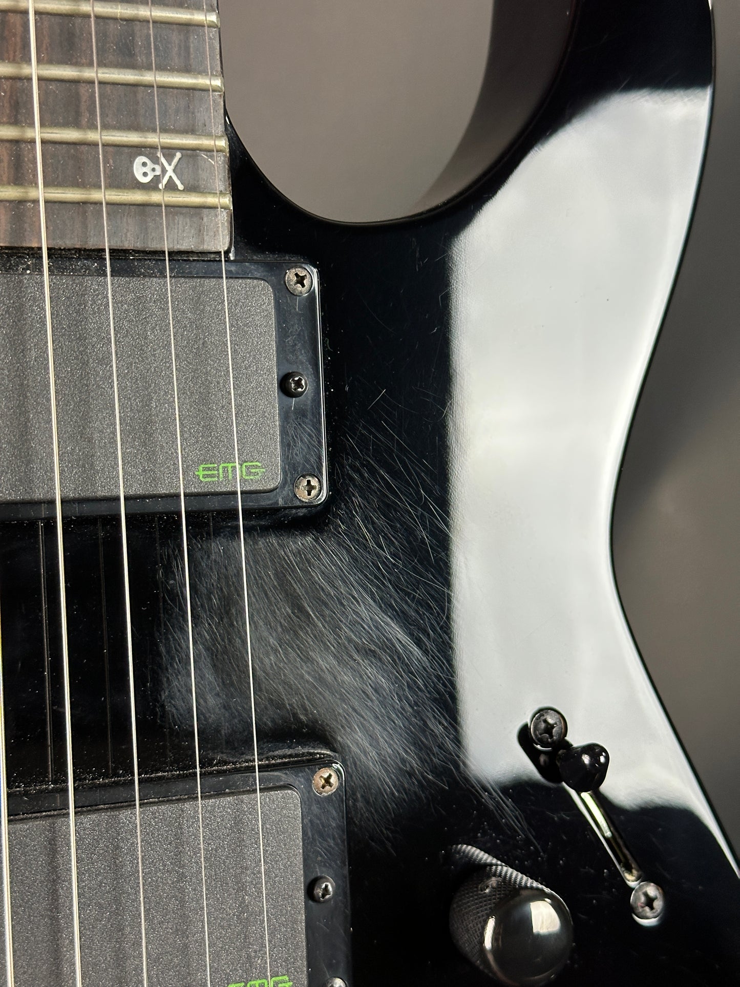 Close-up of a black electric guitar with chrome hardware