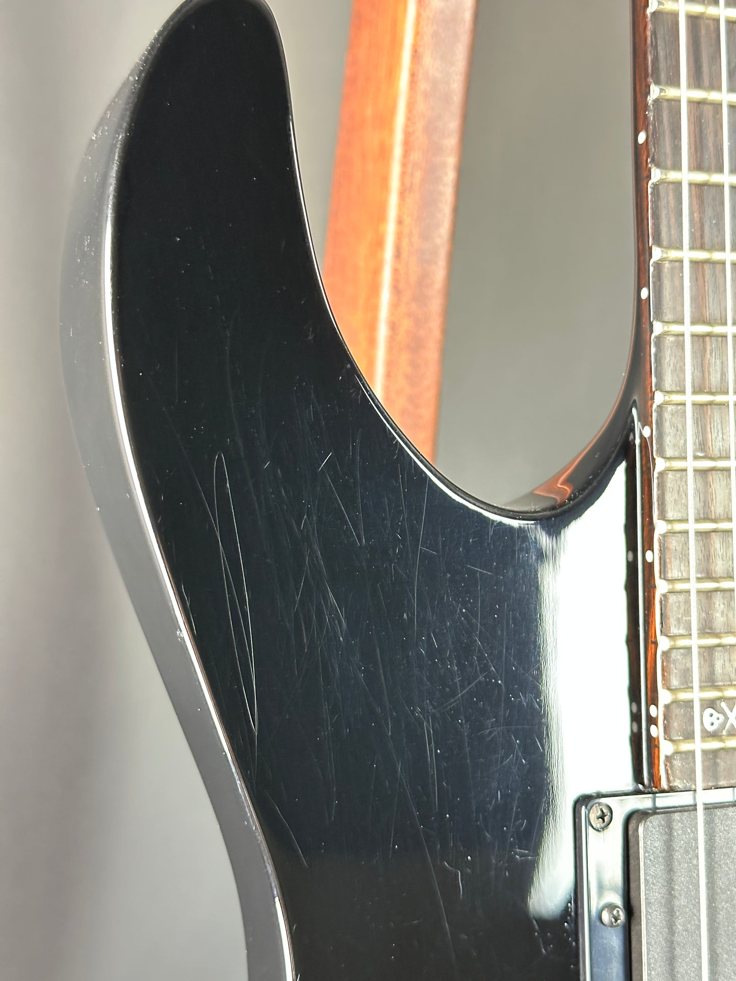 Close-up of a guitar's neck and headstock with visible wear.