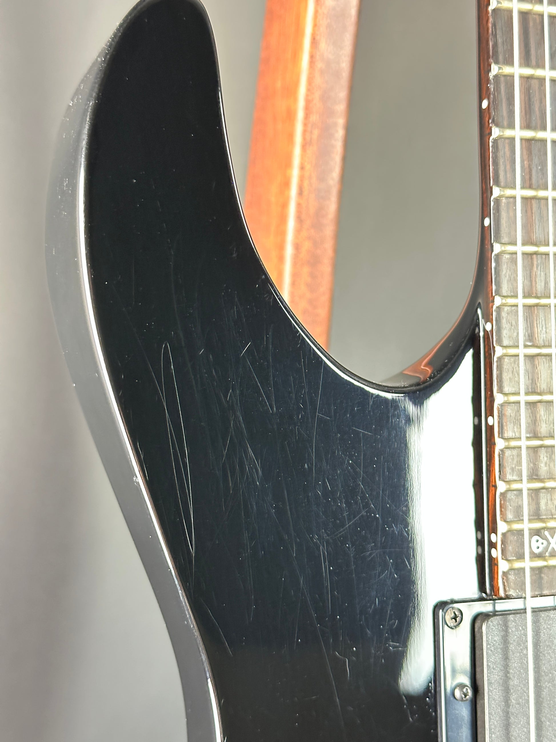 Close-up of a guitar's neck and headstock with visible wear.