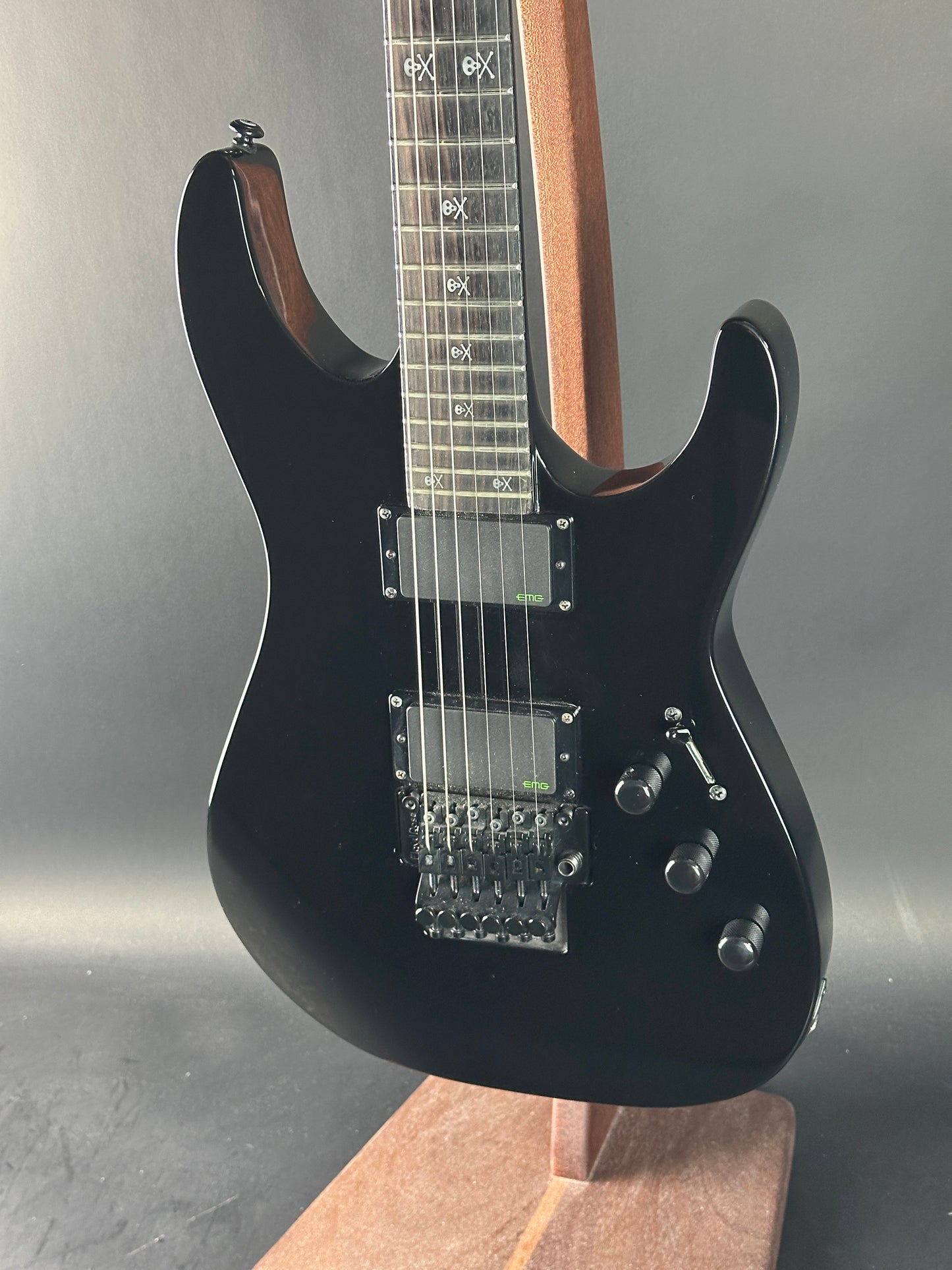 Black electric guitar on a reflective surface with a neutral background