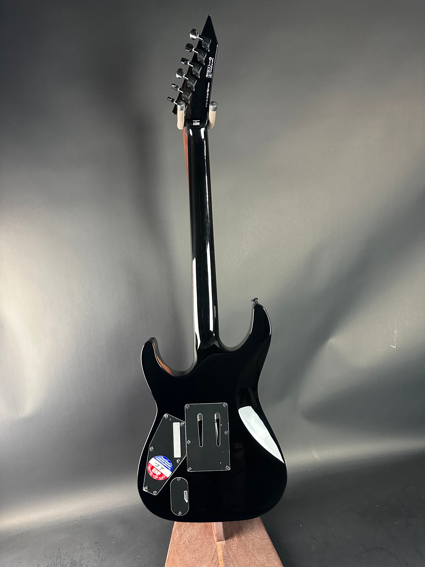 Black electric guitar on a gray background