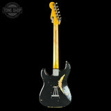 Black electric guitar with a yellow neck on a black background, featuring 'Tone Shop' branding.