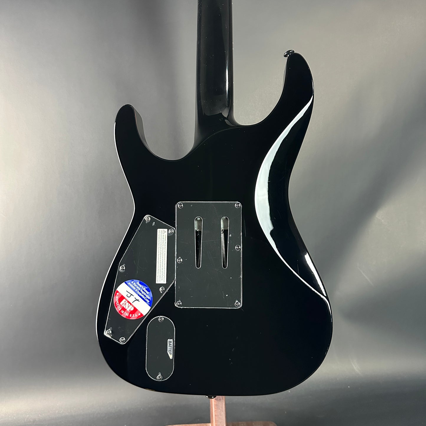 Black electric guitar on a gray background