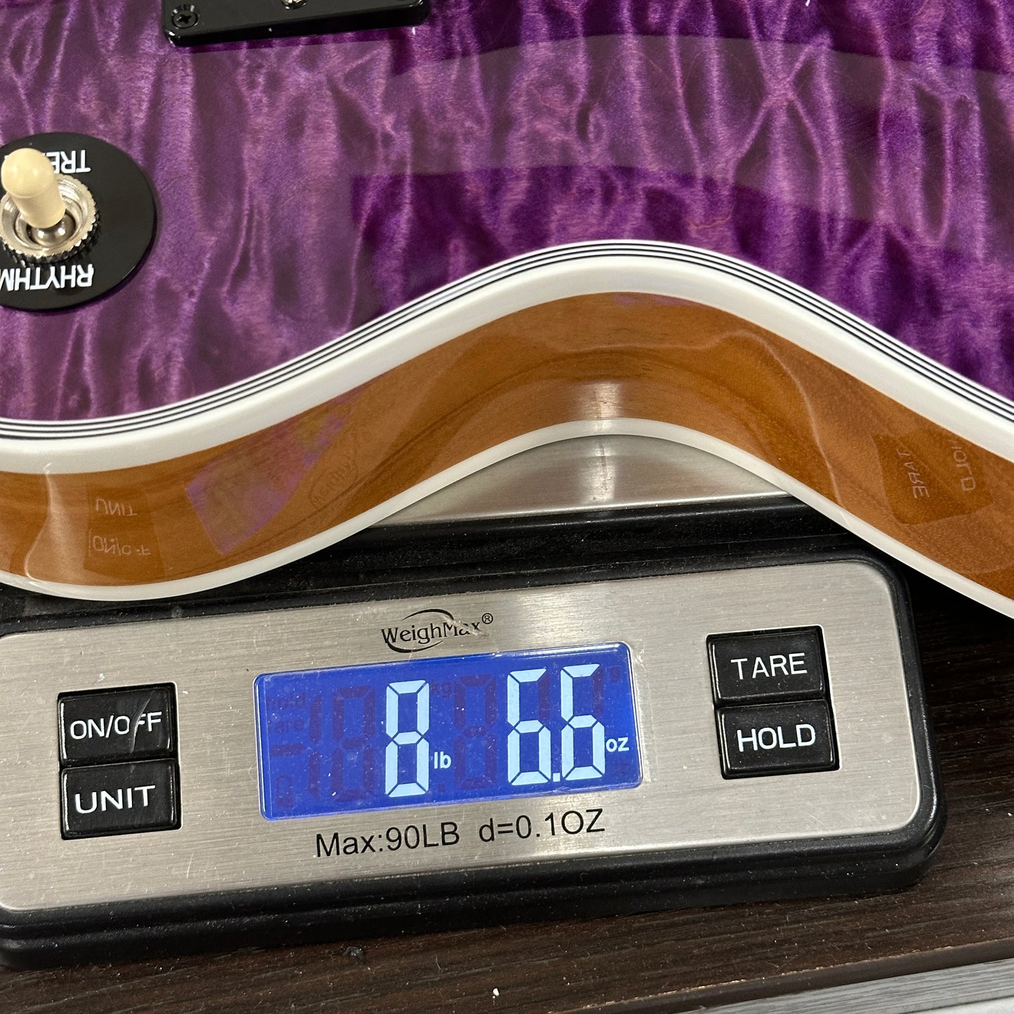 Digital kitchen scale with a purple surface in the background