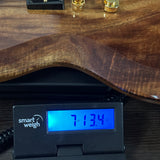 A close-up of a guitar body resting on a digital scale with a Smart Weigh display showing 7.134 lbs.