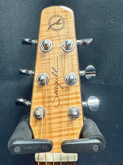 Guitar headstock with Seagull logo and Hercules truss rod on a dark background