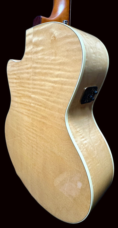 Close-up of a guitar body with a natural wood finish against a dark background