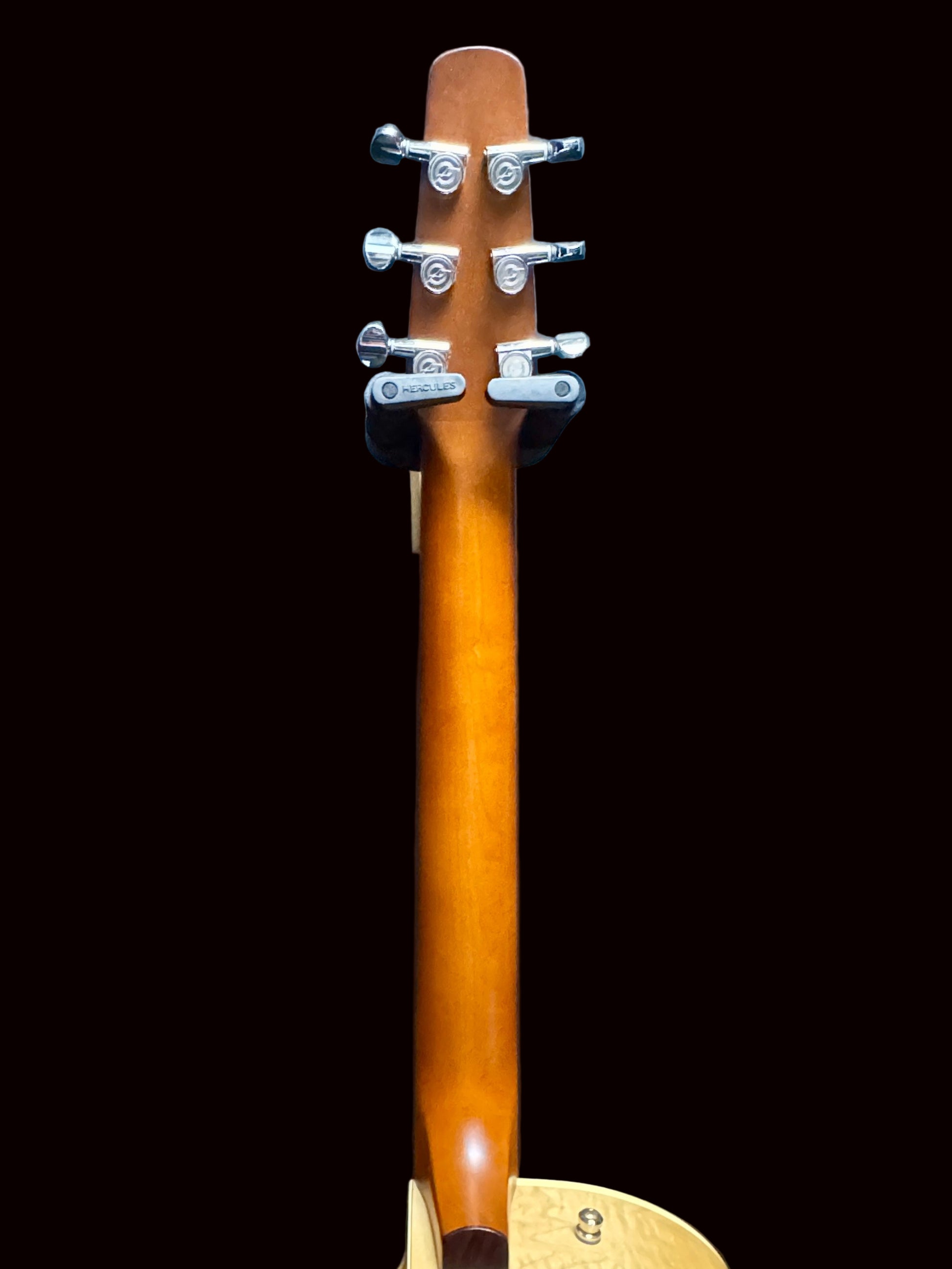 Guitar neck with tuning pegs against a dark blue background