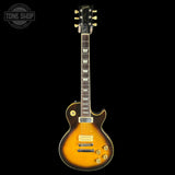 Electric guitar with a sunburst finish on a black background, featuring the Gibson logo.