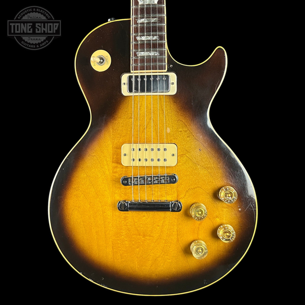 Electric guitar with a sunburst finish on a black background, featuring the Tone Shop logo.