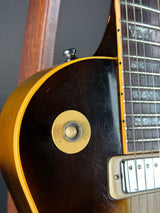 Close-up of a guitar's neck and headstock with a visible brand logo.