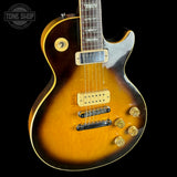 Electric guitar with a sunburst finish on a black background, featuring the Tone Shop logo.