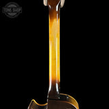 Close-up of a guitar neck with tortoiseshell pattern on a black background, featuring 'Tone Shop' logo.