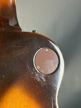 Close-up of a guitar neck with a metal cap and visible wear.