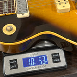Electric guitar on a digital scale displaying weight