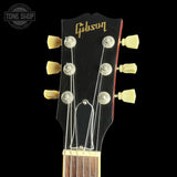 Gibson guitar headstock with tuning pegs on a black background