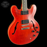 Red electric guitar on a black background with 'Tone Shop' logo.