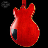 Red electric guitar body with a visible brand logo in the corner.