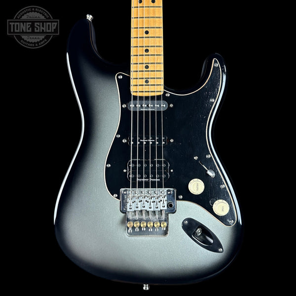 Electric guitar with a metallic finish on a black background, featuring the Tone Shop logo.