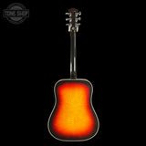 A classic acoustic guitar shown from the back, featuring a vibrant sunburst finish that transitions from black at the edges to a bright orange and red center. The headstock is dark wood with silver tuning keys, set against a solid black background with a Tone Shop watermark in the top left corner.