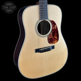 Acoustic guitar with tortoiseshell pickguard on a black background, featuring 'Tone Shop' logo.