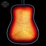 Close-up of the back of an acoustic guitar showing a vibrant sunburst finish that transitions from bright yellow and orange in the center to deep red and black around the edges, set against a solid black background.