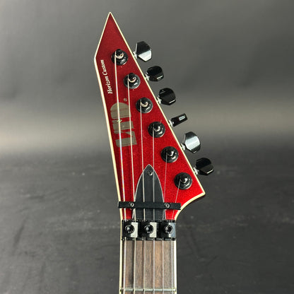 Close-up of a red electric guitar headstock on a gray background
