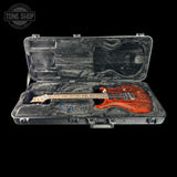 Glossy electric guitar in a hard-shell case with 'Tone Shop' branding.